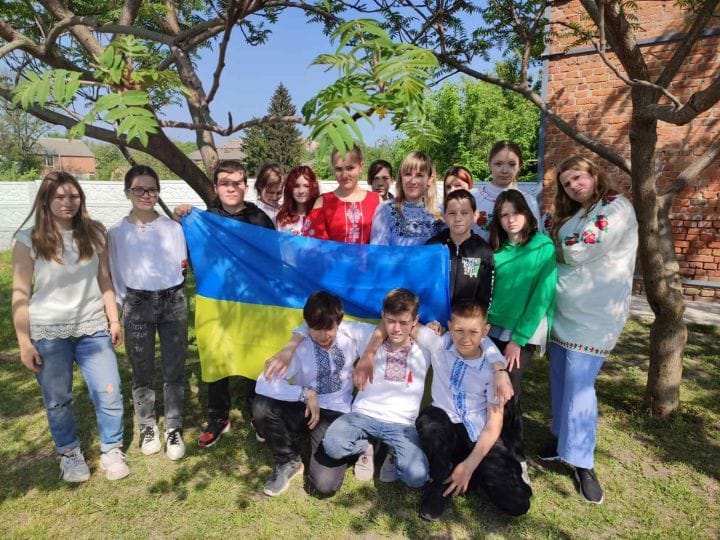 фото у дворі з прапором
